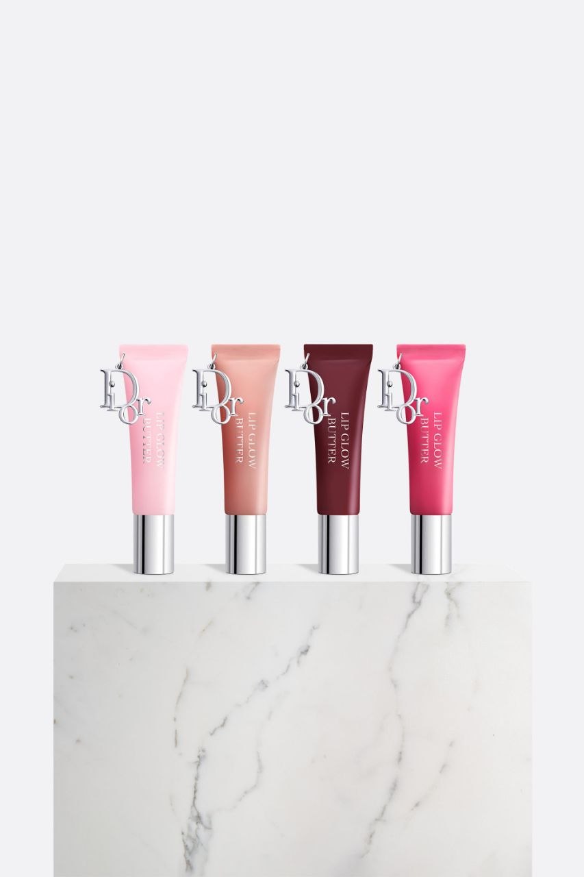 Dior Addict Lip Glow Butter in four shades displayed on marble surface